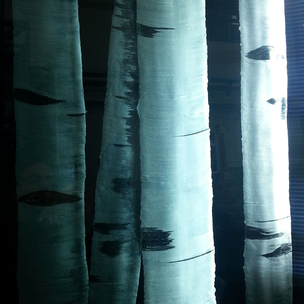 Gläserne Kunstinstallation mit birkenwaldähnlichem Motiv in Blau- und Schwarzschattierungen, die das Licht durchscheinen lässt.