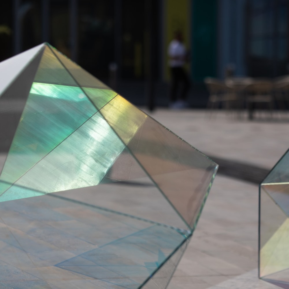 Nahaufnahme der Glaskunst "The Shape of Light" von Shuster und Moseley, Ansicht einer Antiprisme mit Spiegelung