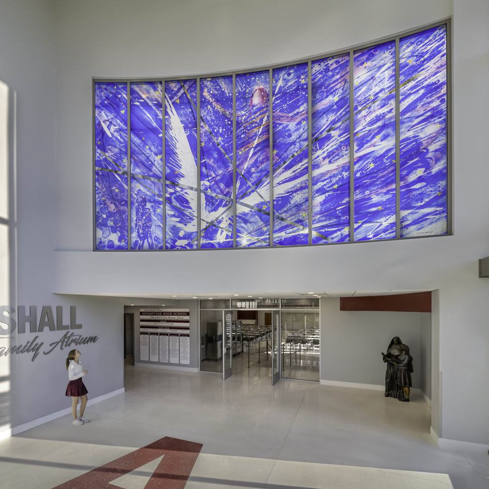 Heller Raum mit einem großen, farbintensiven Buntglasfenster aus blauen und violetten Tönen an der Oberwand.